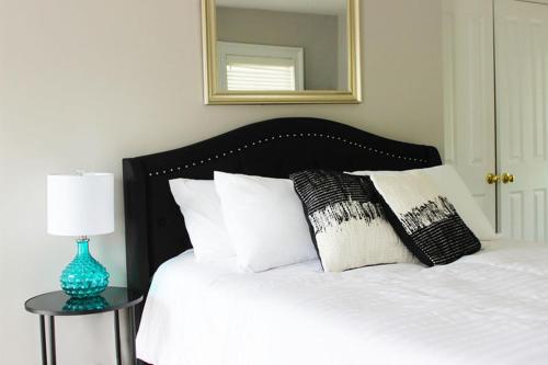 a bed with white pillows and a table with a mirror at The National Hotel in Frenchtown
