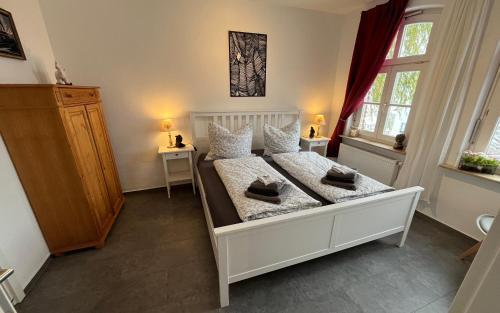 een slaapkamer met een wit bed en 2 ramen bij Ferienwohnung Burghasungen in Zierenberg