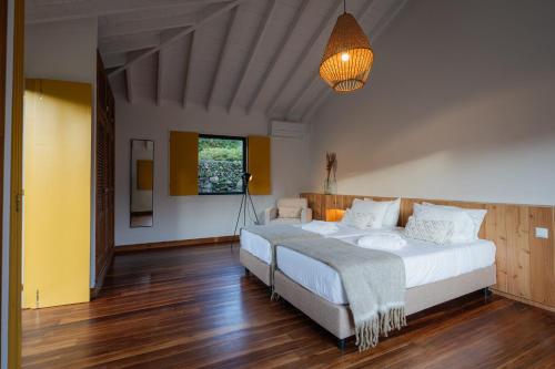 1 dormitorio grande con 2 camas y lámpara en Carmo Country Villas en Ponta Delgada