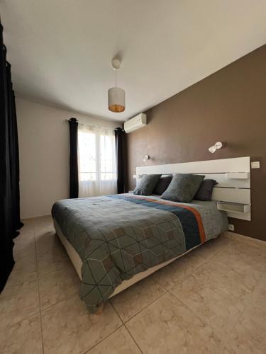 une chambre avec un grand lit dans une pièce dans l'établissement Villa complète, à Nîmes