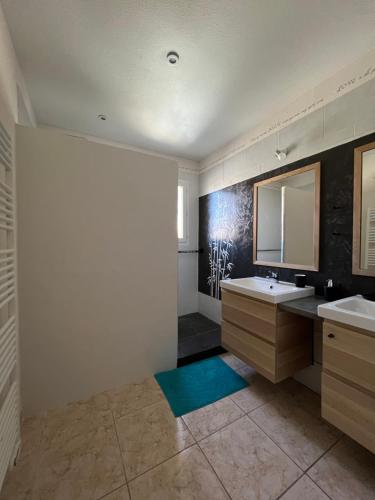 une salle de bain avec deux lavabos et un miroir dans l'établissement Villa complète, à Nîmes