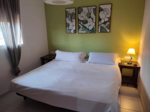 a bedroom with a white bed with two pillows at Babuino house in Rome