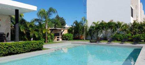 una piscina en un patio con palmeras en Paraíso Casa Turquesa Playa del Carmen en Playa del Carmen