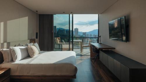 a bedroom with a bed and a view of a city at Kiin Living- "Child-free coliving" in Medellín