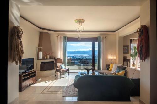 een woonkamer met een bank en een televisie bij Villa Marena with extraordinary views in Agios Nikolaos