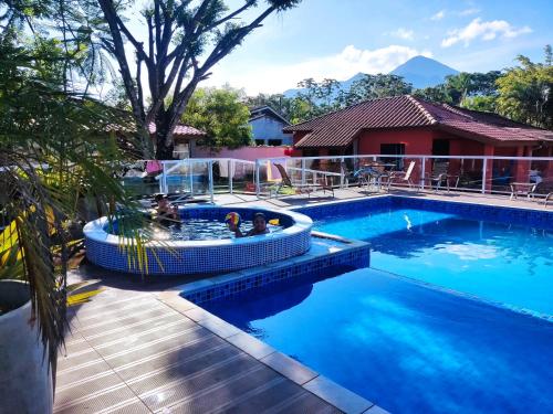 a swimming pool with people in a water slide at Casa de praia Guarau in Peruíbe