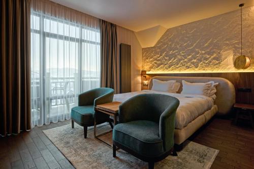a hotel room with a bed and two chairs at F&B Spa Resort (ex. Fomich Hotel) in Bukovel