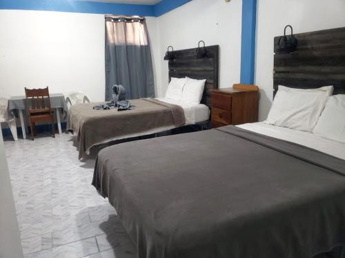 a hotel room with two beds and a table at Beach Side Condos Caye Caulker by CCVH in Caye Caulker