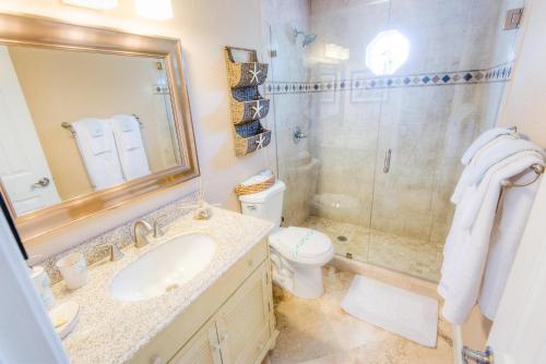 uma casa de banho com um WC, um lavatório e um chuveiro em Pineapple Key em Holmes Beach