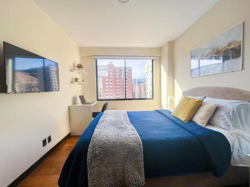a bedroom with a blue bed and a large window at Warm, Bright & Cozy Apartment in the best area of La Paz! in La Paz