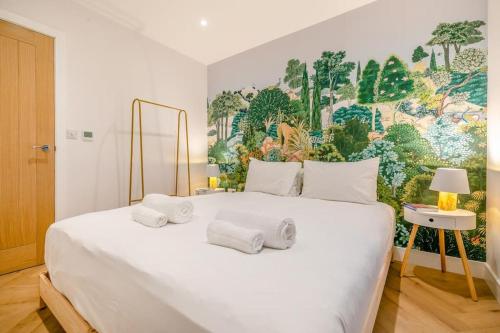 a bedroom with a large white bed with a painting on the wall at Luxury holiday home near the coast in Porthtowan