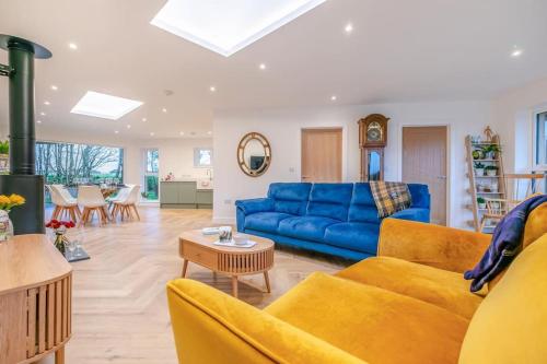 a living room with a blue couch and a table at Luxury holiday home near the coast in Porthtowan