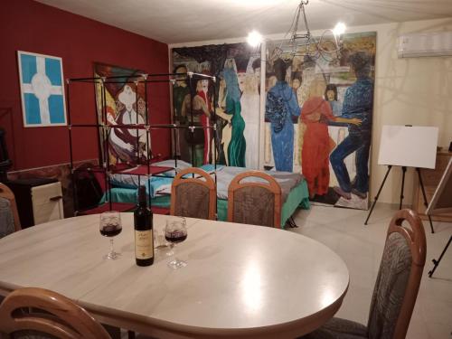 een eetkamer met een tafel en twee glazen wijn bij Lazar Apartmani 