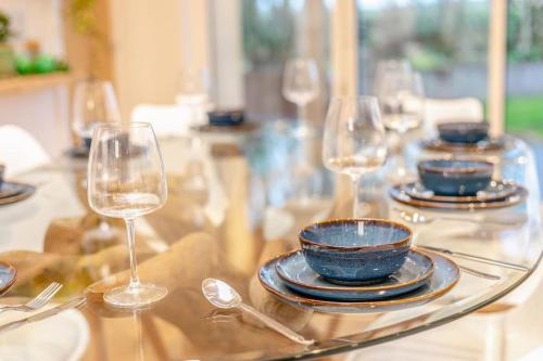 a table with wine glasses and plates on it at Luxury holiday home near the coast in Porthtowan
