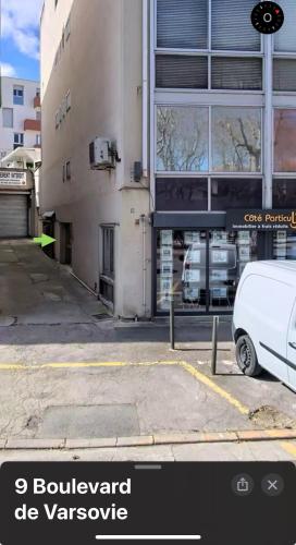 ein weißer Lieferwagen, der auf einem Parkplatz neben einem Gebäude geparkt ist in der Unterkunft Appartement - Carcassonne Centre in Carcassonne