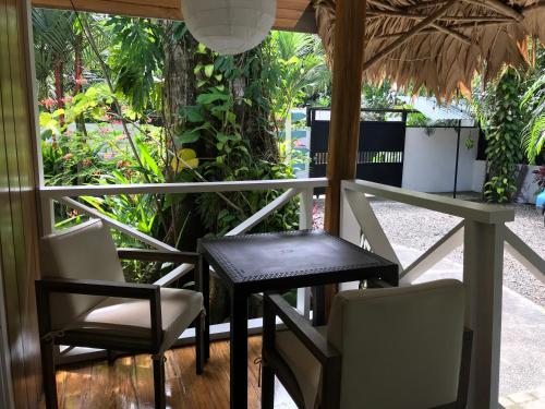 a table and chairs on a balcony with plants at Casa ANA KIMBA in Puerto Viejo
