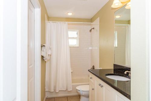 een badkamer met een wastafel, een toilet en een douche bij Seabreeze Cottage in Holmes Beach