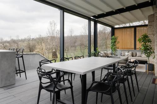 een terras met een tafel en stoelen bij Villa The Frame in Comarnic