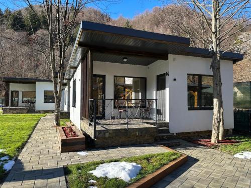 ein Haus mit einer Veranda mit einer Terrasse in der Unterkunft Indigo Resort in Moieciu de Jos