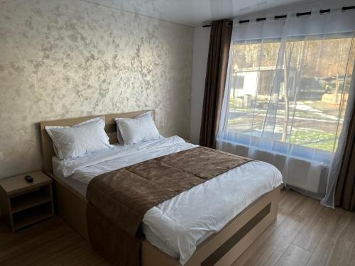 una camera da letto con un letto e una grande finestra di Indigo Resort a Moieciu de Jos