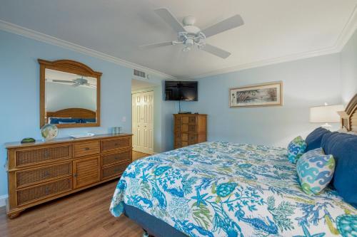 a bedroom with a bed and a dresser and a mirror at Runaway Bay in Bradenton Beach