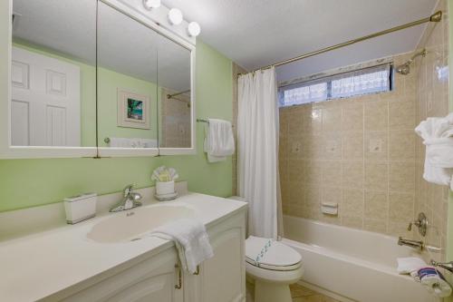 a bathroom with a sink and a toilet and a tub at Runaway Bay in Bradenton Beach