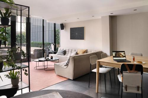 een woonkamer met een bank en een tafel met een laptop bij Sonder Park House in Amsterdam