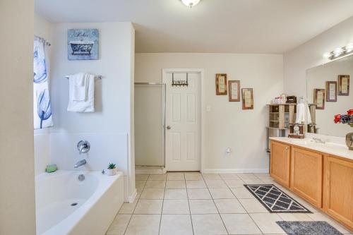 a bathroom with a tub and a sink at Spacious Family-Friendly Home in Denham Springs! in Denham Springs