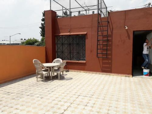 a patio with a table and chairs next to a building at Foro sol autódromo aeropuerto in Mexico City