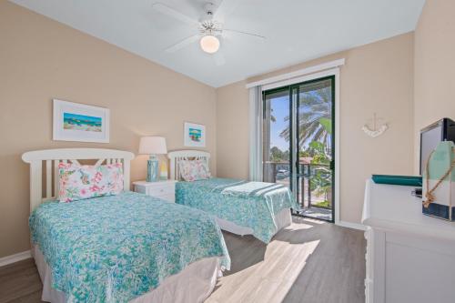 1 dormitorio con 2 camas y ventana en The Reefs Edge, en Holmes Beach