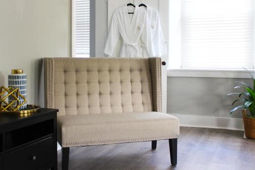 a white robe hanging in a window next to a chair at The National Hotel in Frenchtown