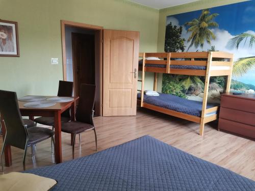 ビャウォグラにあるPokoje Goscinne MAXIMのベッドルーム1室(二段ベッド1組、テーブル付)、ダイニングルームが備わります。