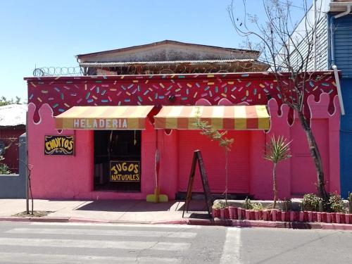 a pink building on a street corner with aemediahemetery at Casa Rosa Hostel in Santiago