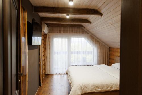 ein Schlafzimmer mit einem Bett und einem großen Fenster in der Unterkunft Wild River in Neporotovo