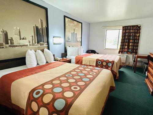 um quarto de hotel com duas camas e uma janela em Super 8 by Wyndham Imlay City em Imlay City