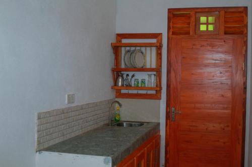 una cucina con lavandino e porta in legno di Yino Villa Midigama a Midigama East