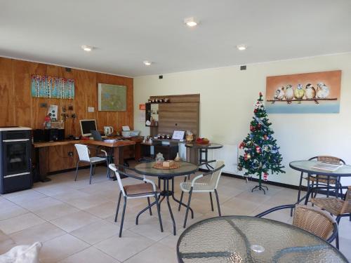 uma sala com mesas e uma árvore de Natal em Verdevida Apart Hotel em Pucón