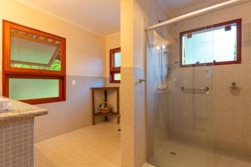 a bathroom with a shower with a glass door at Hotel Velas do Engenho in Ilhabela