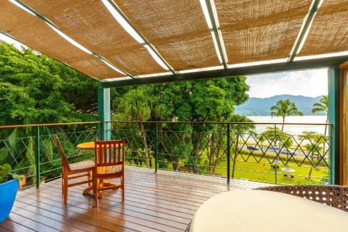 a room with a balcony with a view of the ocean at Hotel Velas do Engenho in Ilhabela