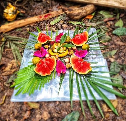 a plate of fruit on top of a palm leaf at Tropical Jungle Hut in Bukit Lawang