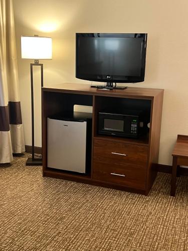a flat screen tv on a entertainment center in a hotel room at Comfort Inn in Manistique
