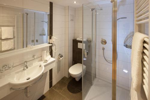 a bathroom with a toilet and a sink and a shower at Dorfgasthof Adler in Mellau