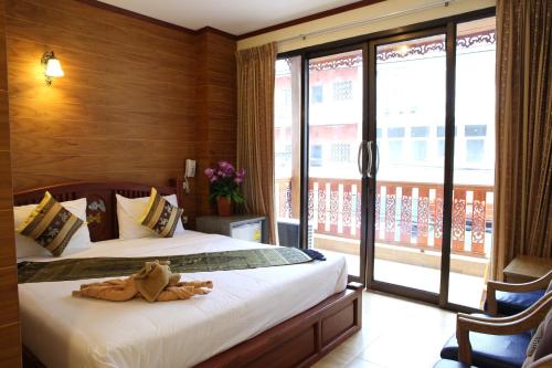 um quarto com uma cama e uma grande janela em Tanee Place em Bangkok