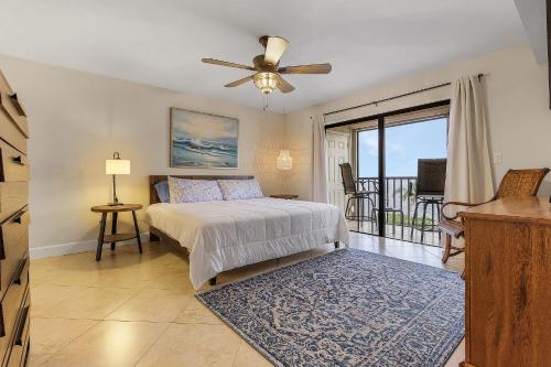 a bedroom with a bed with a ceiling fan and a balcony at RIVERFRONT VIEW, Stunning Sunrises, Community Pool - Condo Waterfront Sunrise - Roelens in Cape Coral