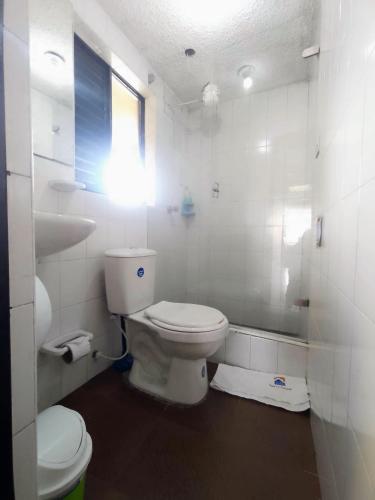 a white bathroom with a toilet and a sink at Apartamentos CasaMJ Tunja Confort y Parqueadero in Tunja