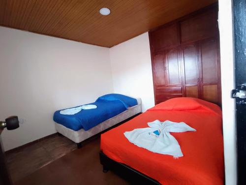 two beds in a room with red and blue at Apartamentos Casa MJ Tunja in Tunja