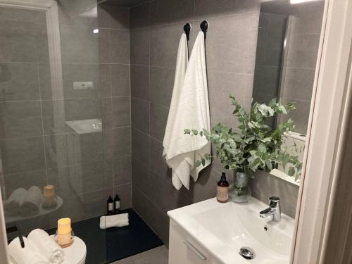 a bathroom with a white sink and a shower at Edén Luxury Suites in Granada
