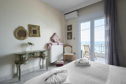 a bedroom with a bed and a table and a window at Pefkohori Blue View by Luxlikehome in Pefkochori
