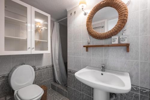 a bathroom with a sink and a toilet and a mirror at Pefkohori Blue View by Luxlikehome in Pefkochori