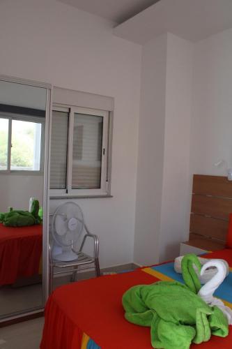a bedroom with two beds and a window and a chair at Sea View Big Lanche in Praia Baixo